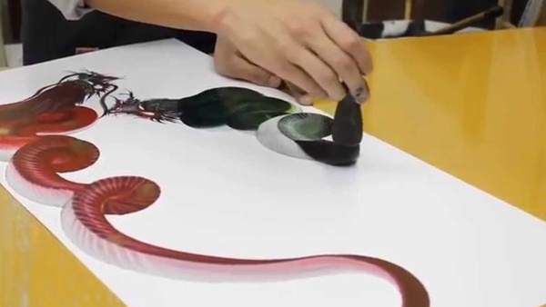 شاب يرسم ثعبان بسحبة فرشاة